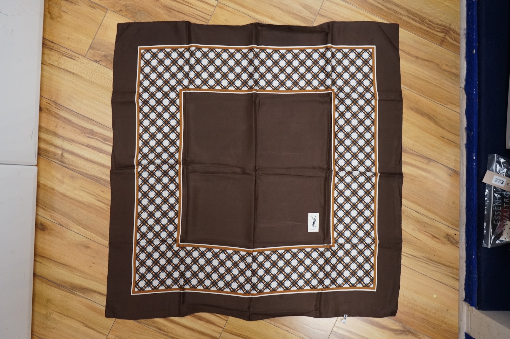 Two Yves Saint Laurent silk scarves comprising a monogrammed example and a patterned brown example with Foulards folding case